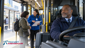 Bus operator seated at the wheel while a transit ambassador helps a passenger with directions near the open bus entrance.